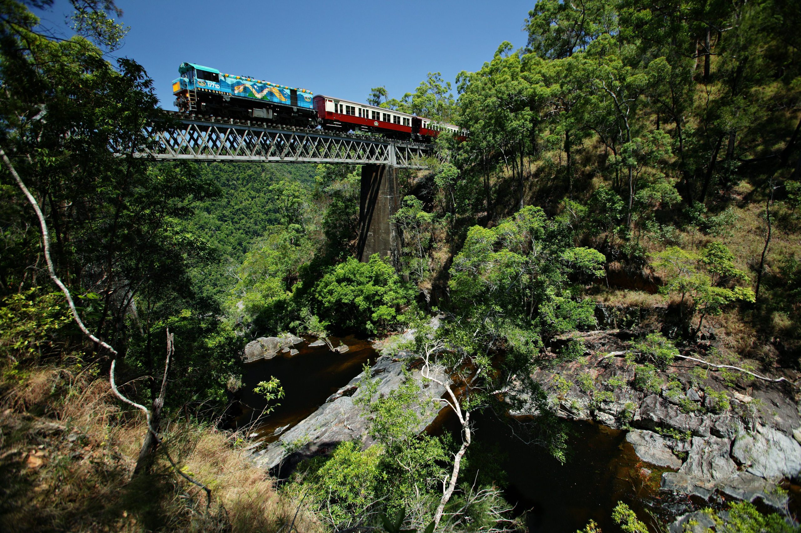 Kuranda Scenic Railway crosses over an old wooden bridge at Surprise Creek near Cairns