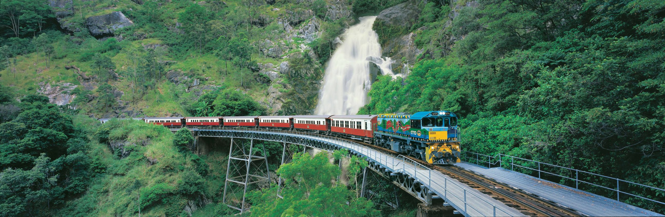 Kuranda Scenic Railway crossing over Stoney Creek bridge with waterfall in the background