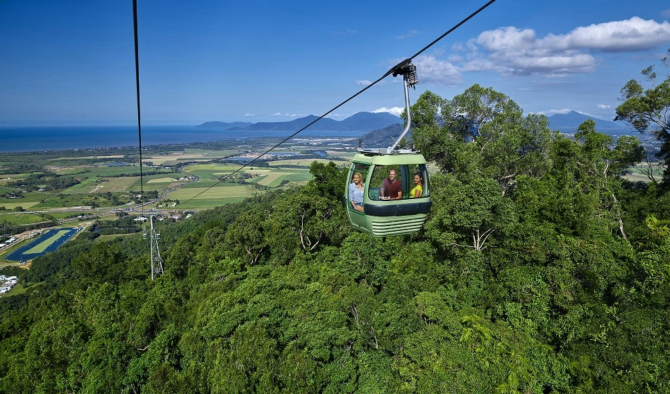 Official Skyrail image overlooking coral sea with rainforest in the background