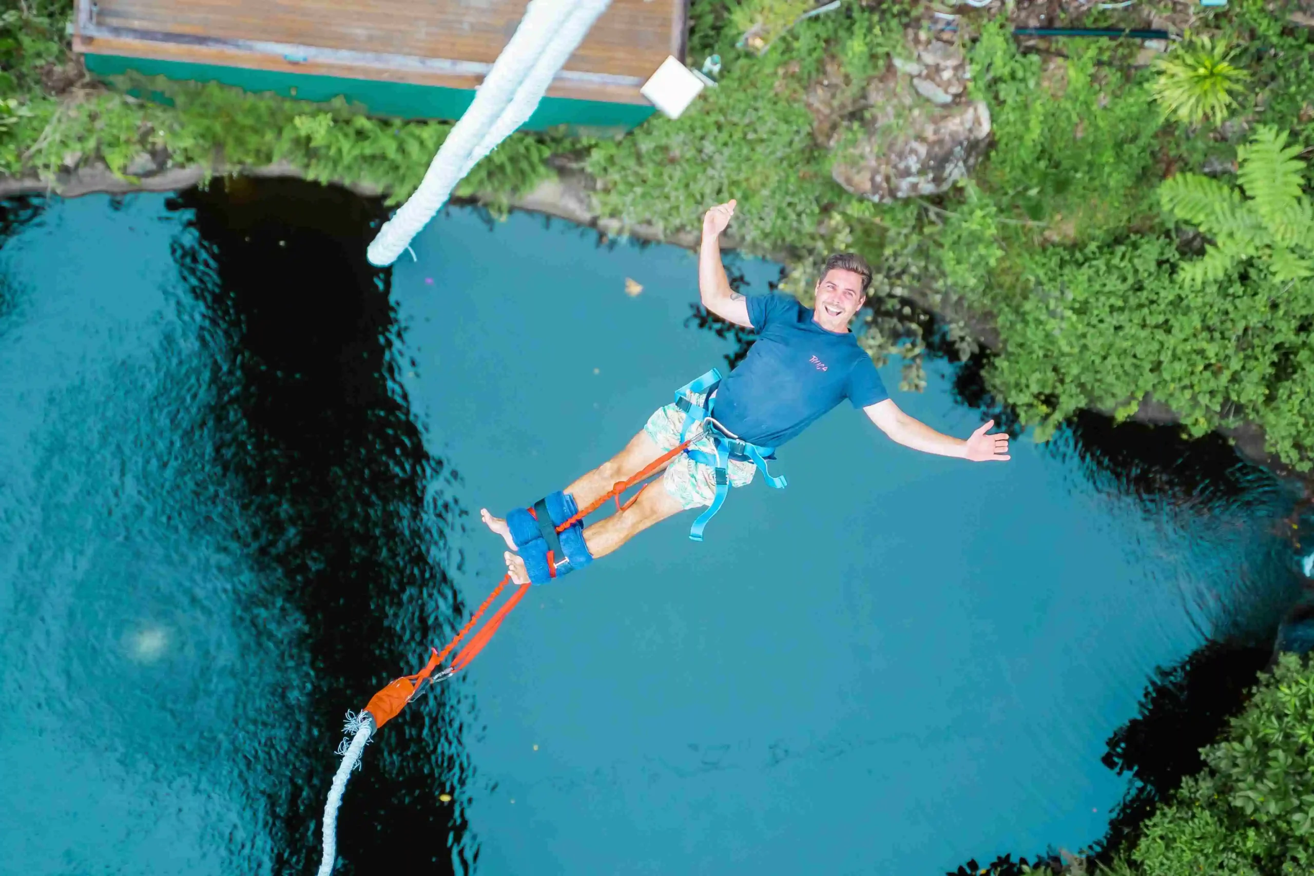 Man bungy jumping backwards over a lake