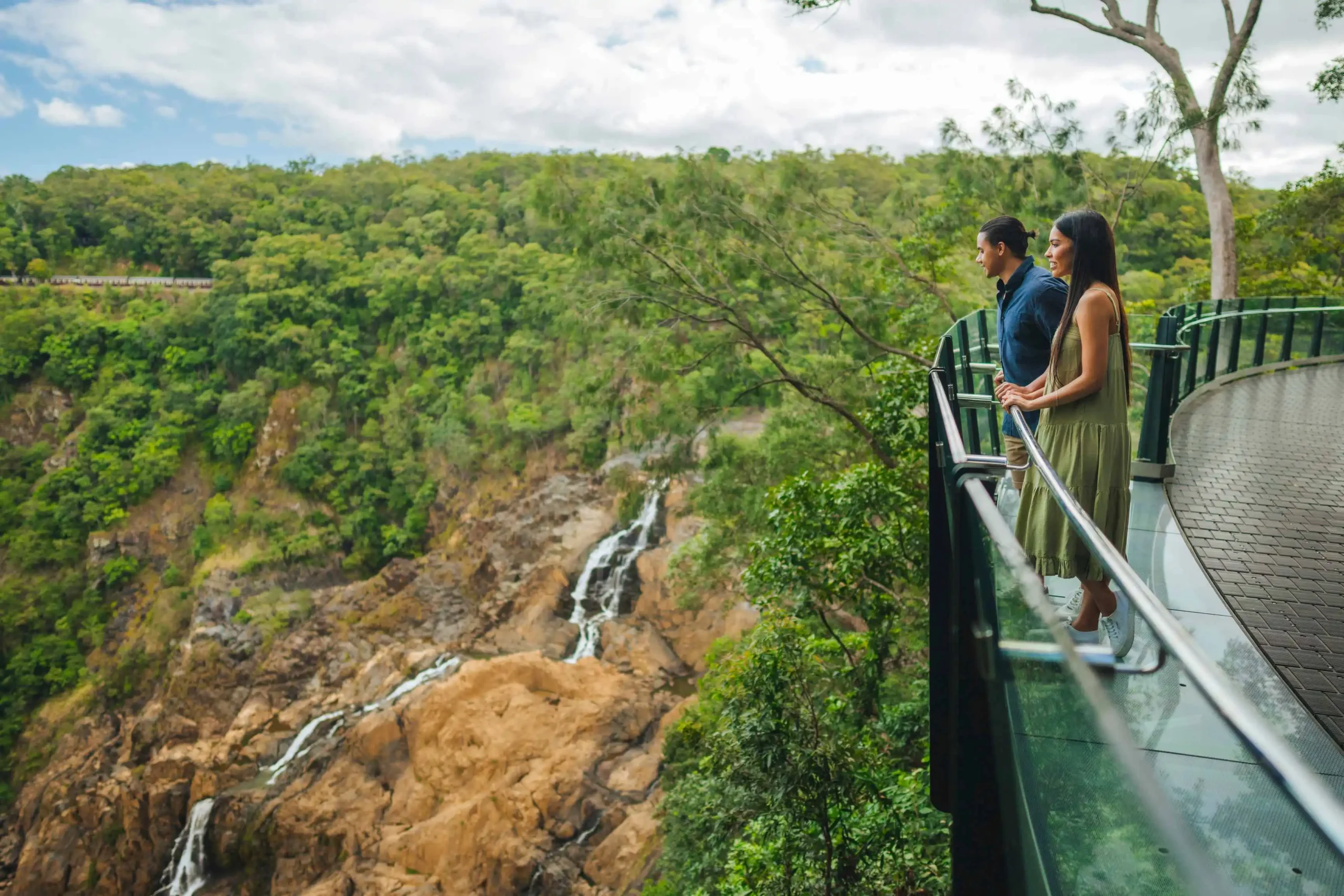 Skyrail's-The-Edge-Lookout.-Two-guests-standing-on-the-glass-edge-viewing-the-Barron-Falls