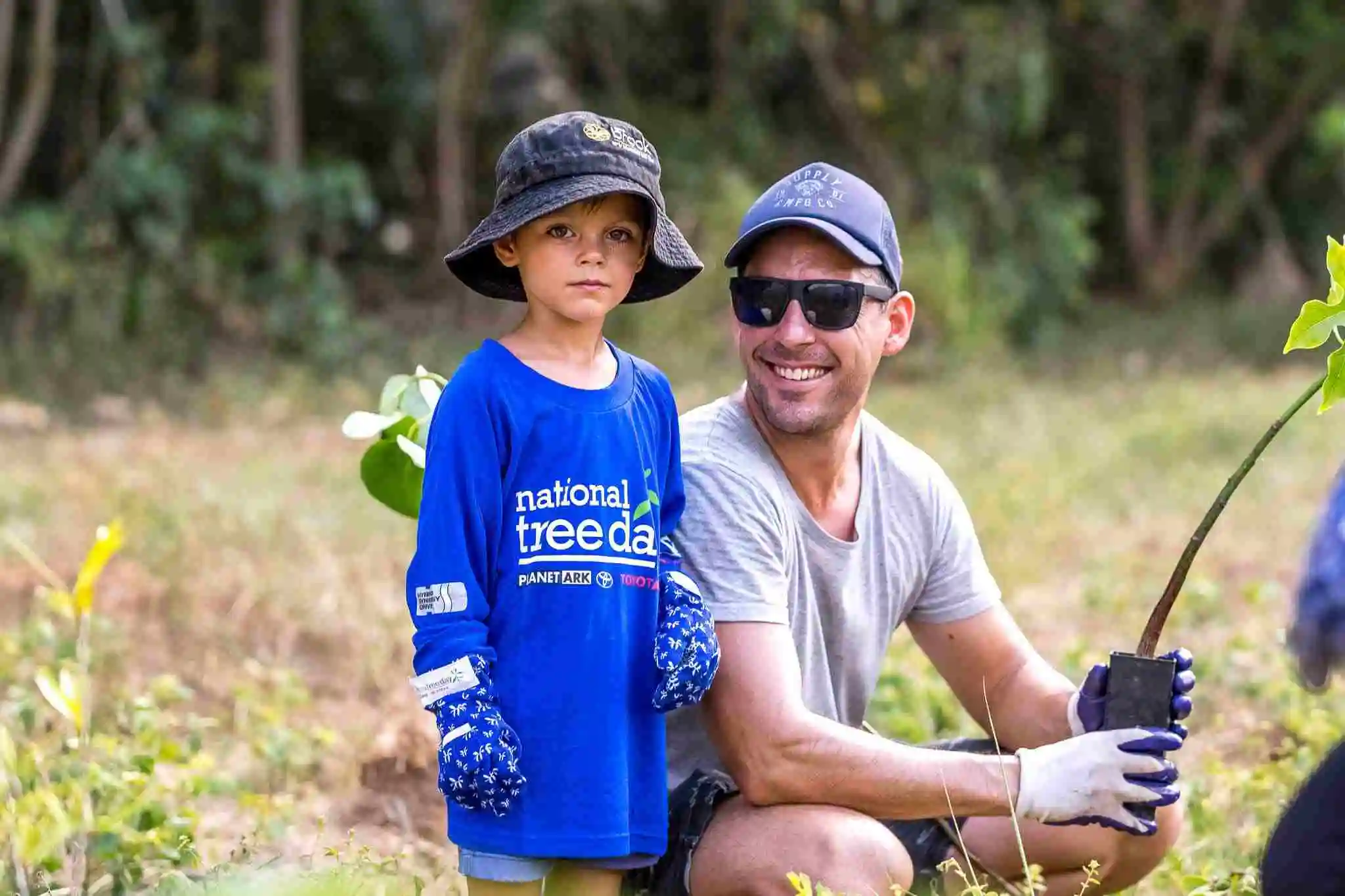 A man and boy plating a tree