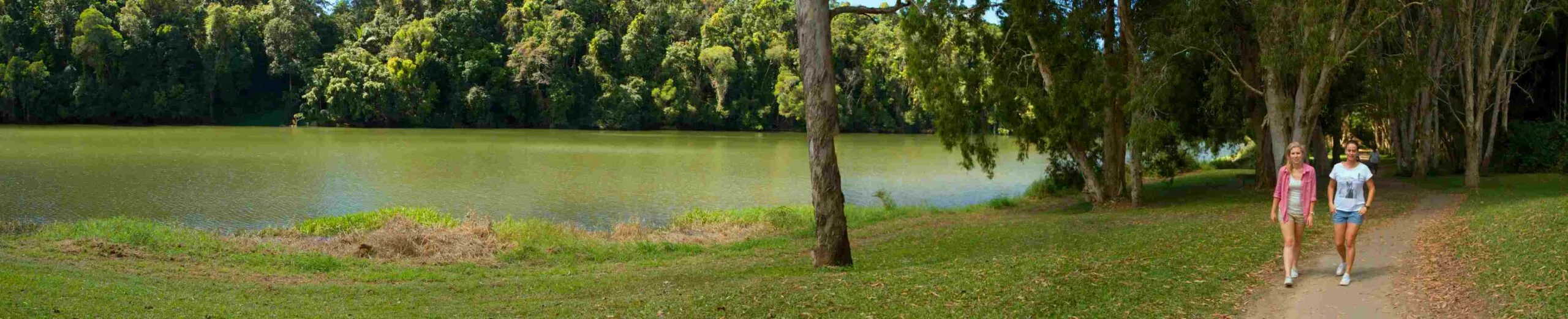 Two females walk beside a river