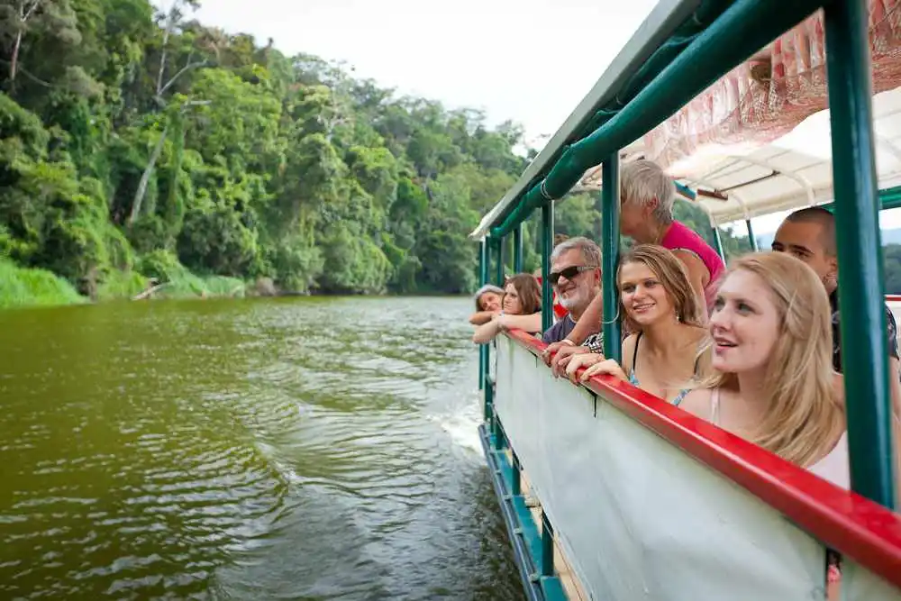 Guests looking over the side of the Kuranda Riverboat as it cruises the Barron River