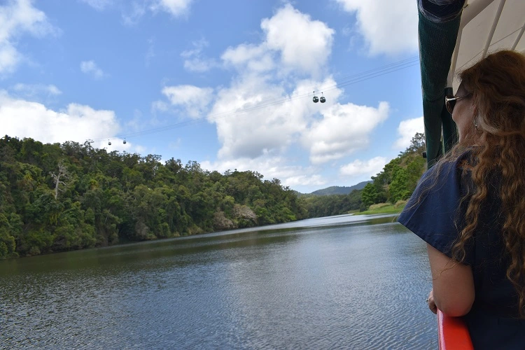 Kuranda riverboat crusing the barron with Skyrail Rainforest Cableway high above in the background