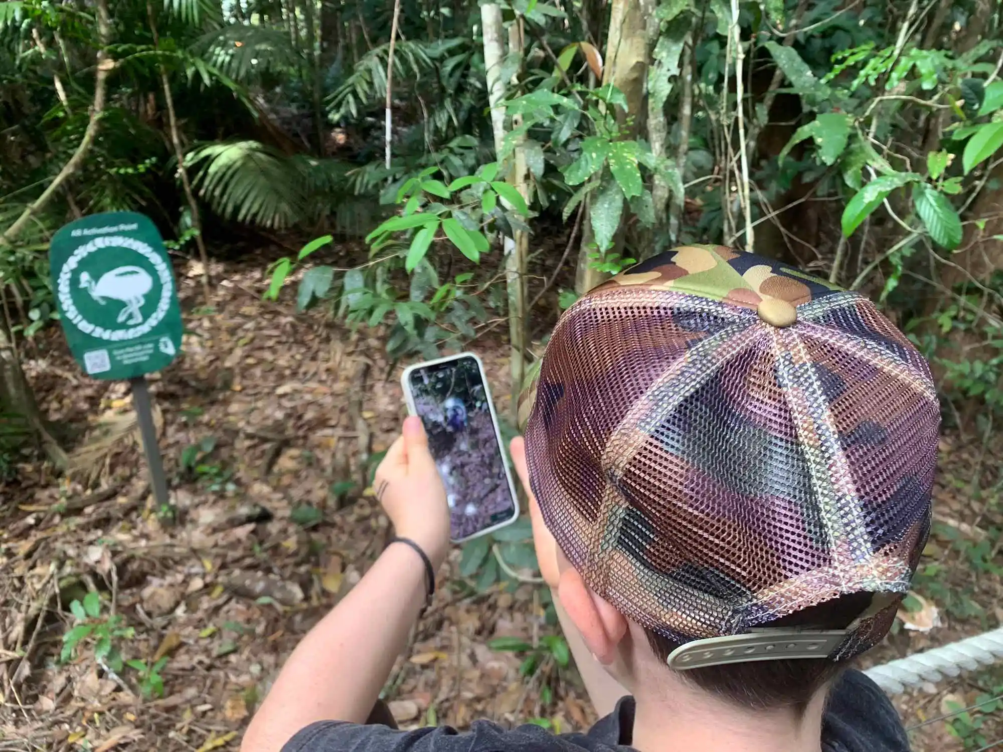 Looking at an Augmented Reality point from behind a boy wearing a cap.