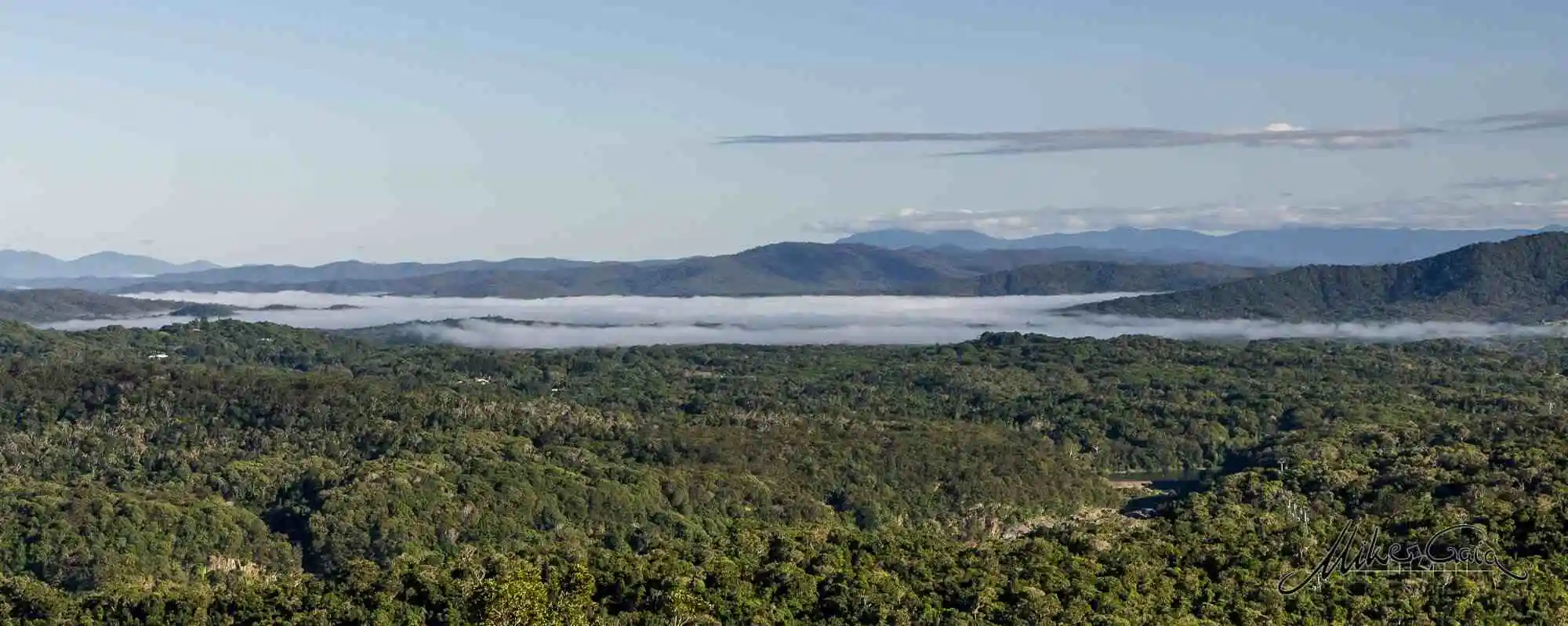 cloud rising in the far distance from the vast rainforest canopy