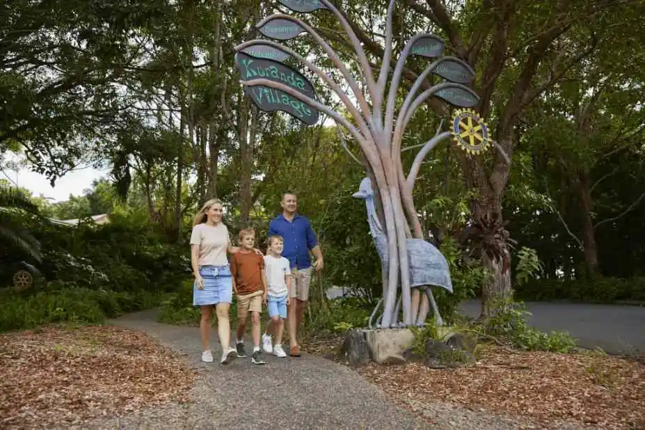 Family of 2 adults and 2 children strolling along Kuranda village pathways