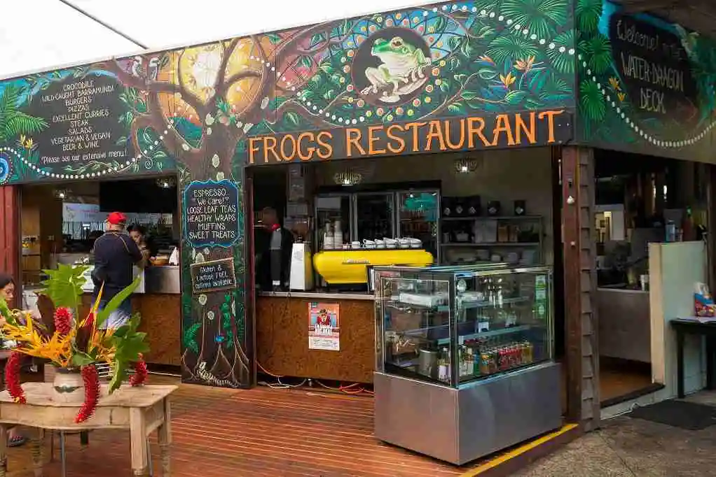 Hand painted shop front detailing frogs and dense jungle wines with coffee machine and food cabinets out the front
