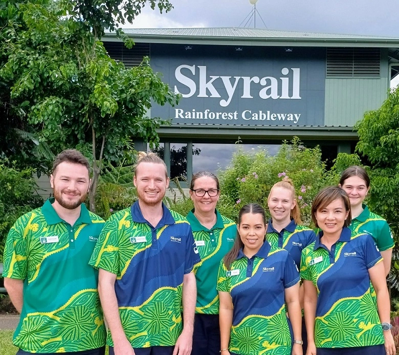 group of skyrail staff standing in front of smithfield terminal in indigenous designed uniform